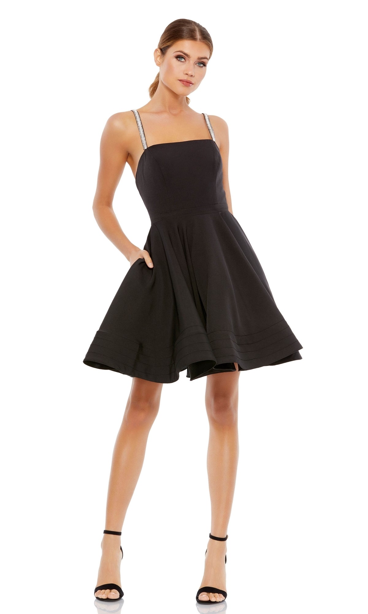 A woman models the Short Black A-Line Fancy Party Dress 49106 with thin straps and black high-heeled sandals against a white background.